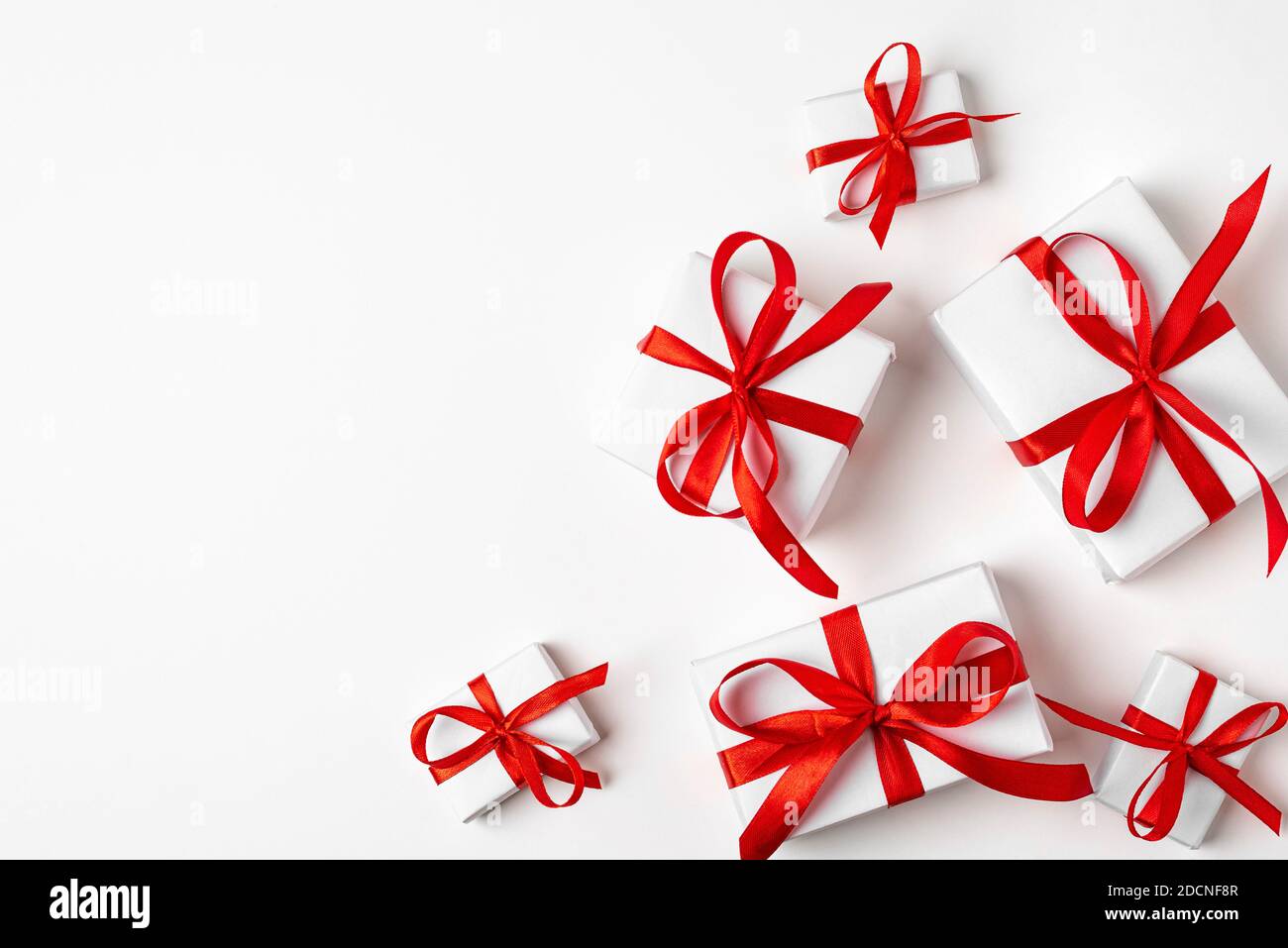 White gifts with red ribbon, present on white background. top view. Happy Holidays. Valentine's day. Birthday. Merry Christmas and Happy New Year Stock Photo