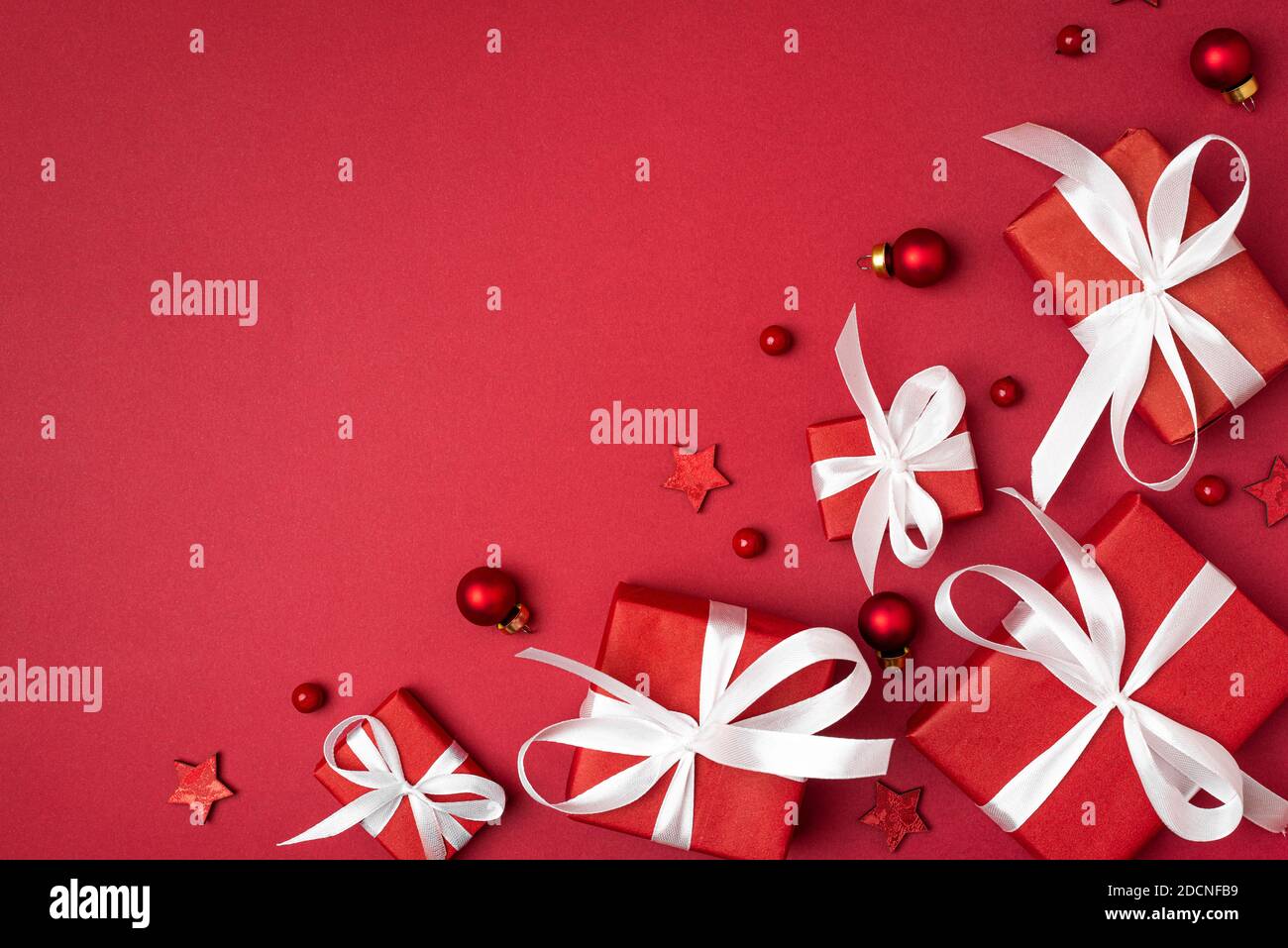 Christmas red gifts with white ribbon on red background. top view. flat lay. Happy winter holidays. Merry Christmas and Happy New Year greeting card Stock Photo