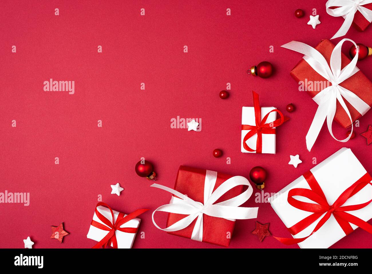 Merry Christmas and Happy New Year greeting card. Red and white Christmas gift boxes on red background. top view. Winter xmas holiday concept. Flat la Stock Photo