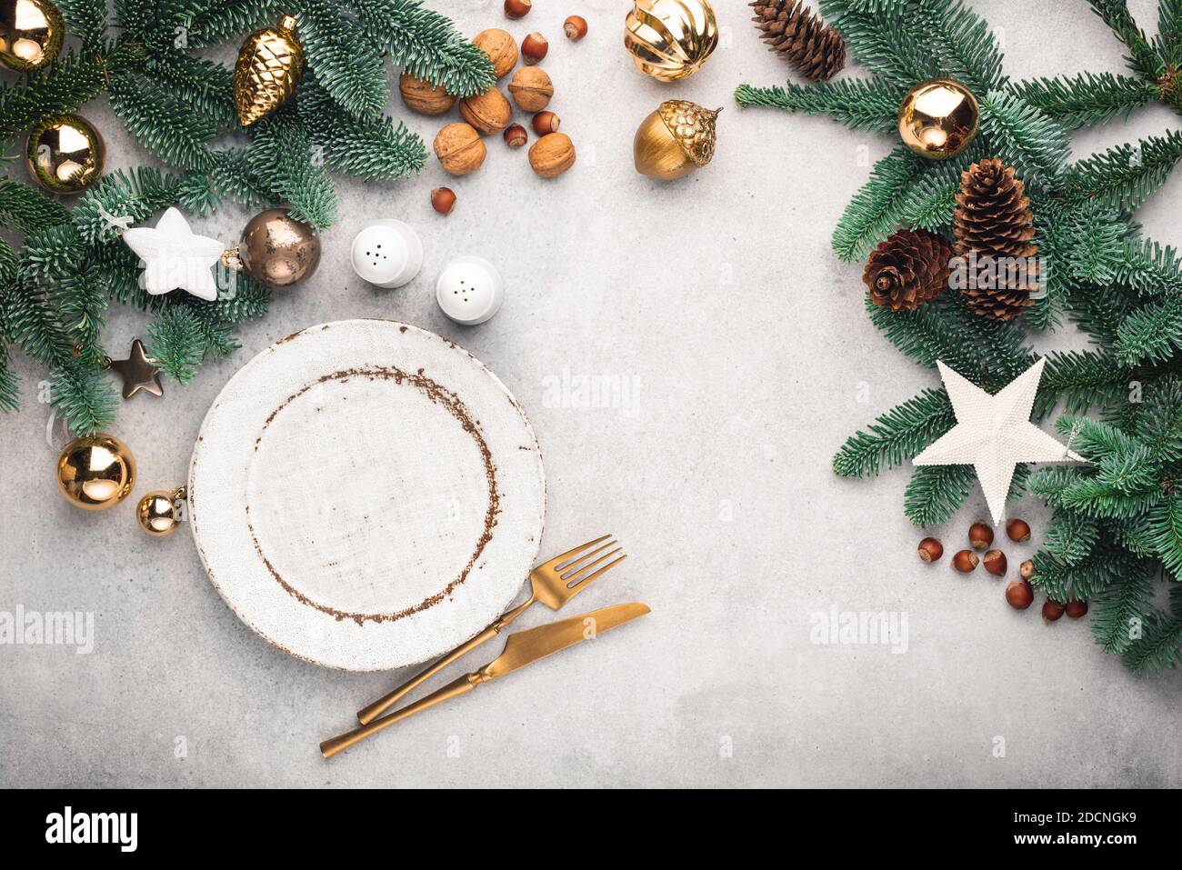 Christmas or New Year table setting mock up or frame with copy space for design elements and text. Top view. Empty plate, cutlery, fir tree and Christ Stock Photo
