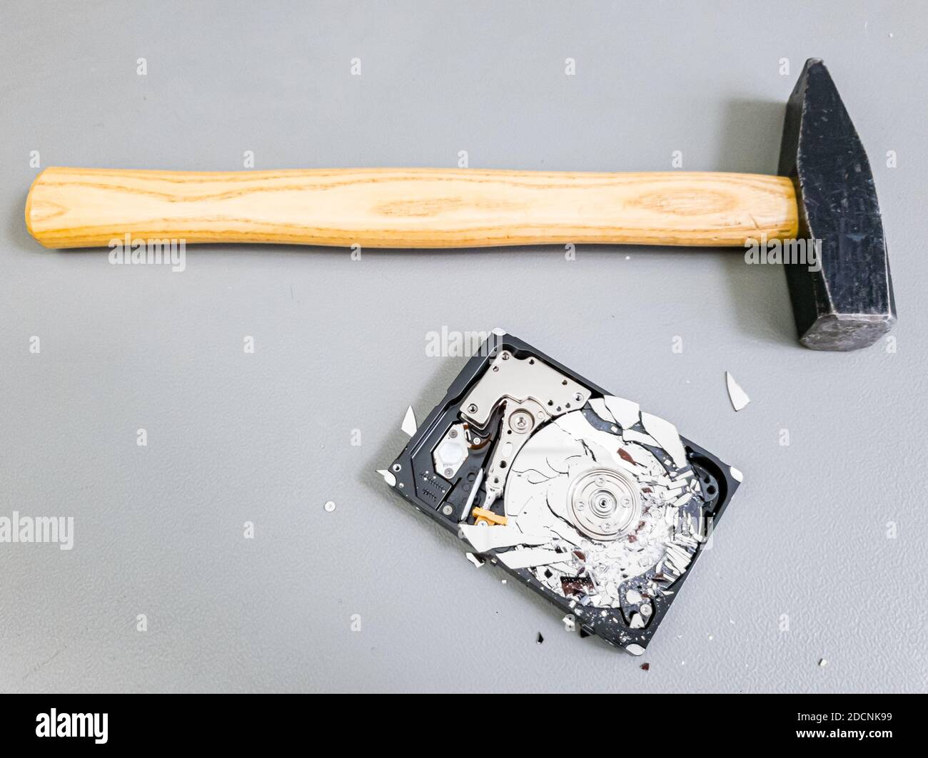 Shattered platter in computer hard drive disk and a hammer Stock Photo