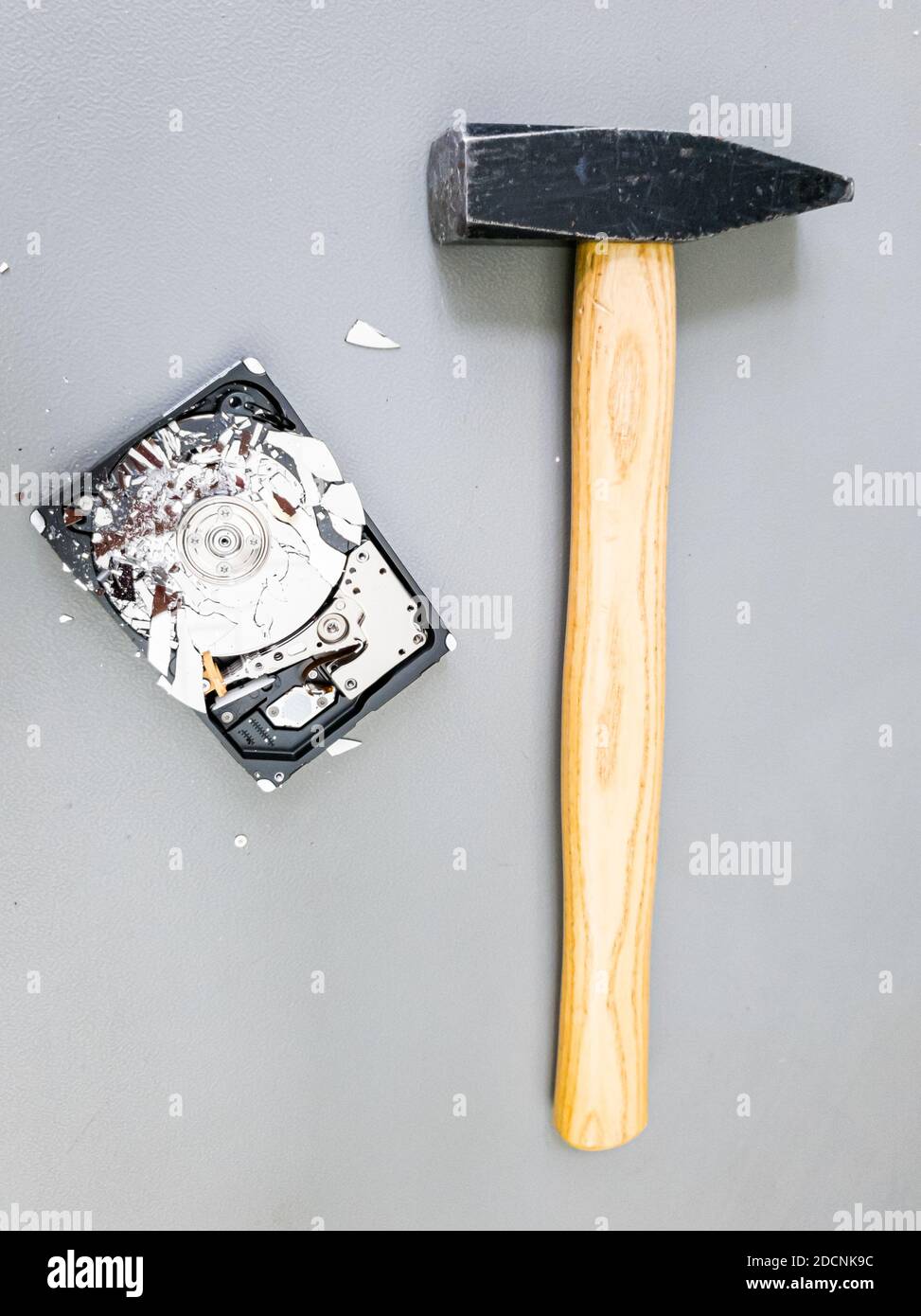 Shattered platter in computer hard drive disk and a hammer Stock Photo