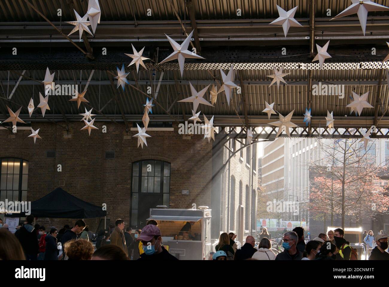 Canopy Market with star shaped Christmas decorations dangling from the ceiling. Coal Drops Yard, Kings Cross, London. Stock Photo