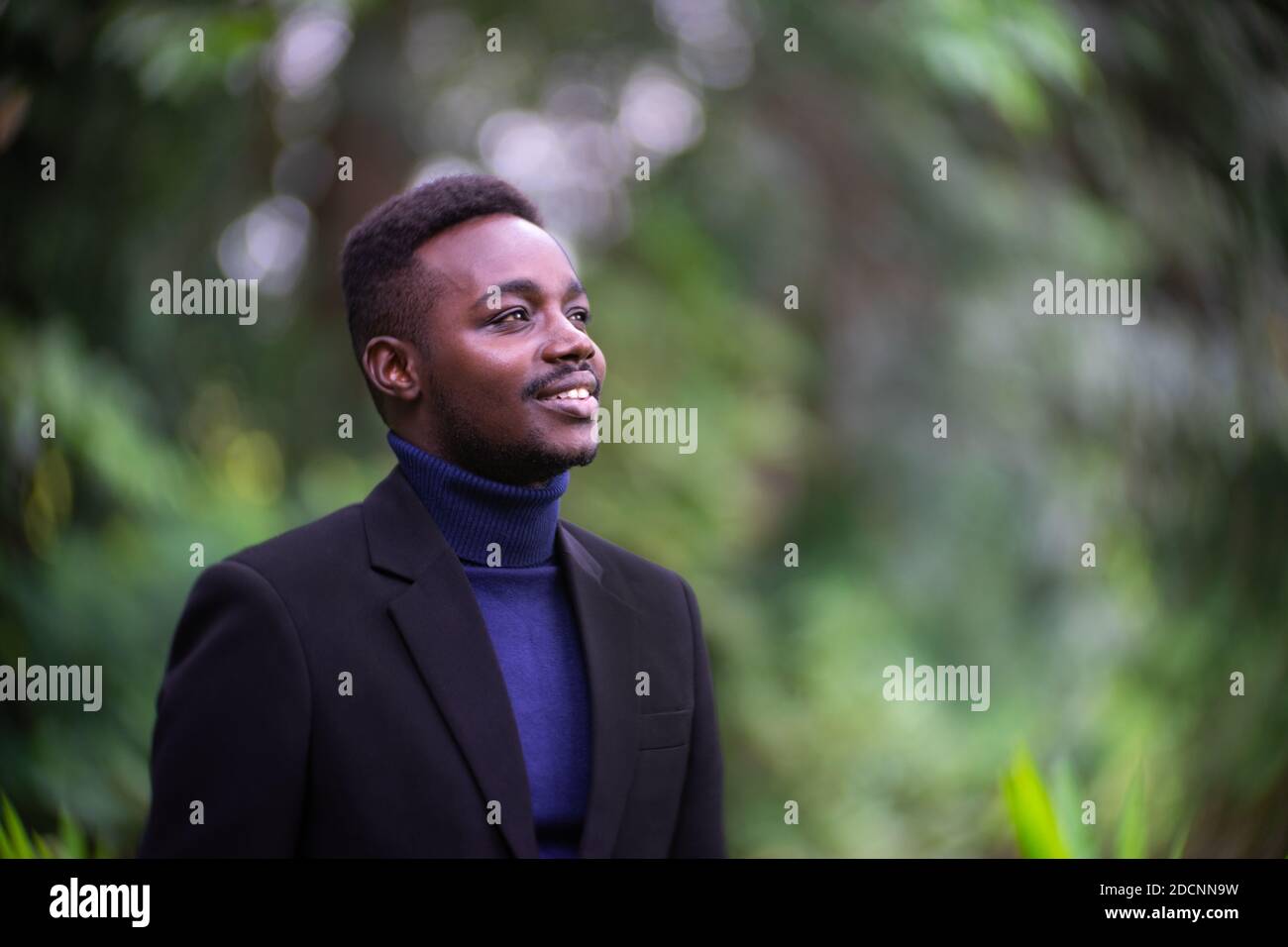 Handsome african business man in trendy formal black suit. Guy with beard  wearing blue long sleeve or sweater Stock Photo - Alamy
