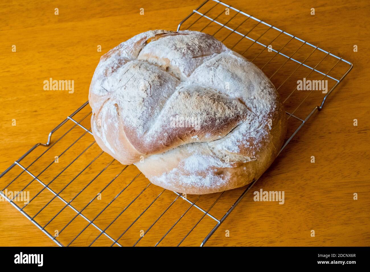 Freshly baked loaf of bread cooling on a wire rack Stock Photo