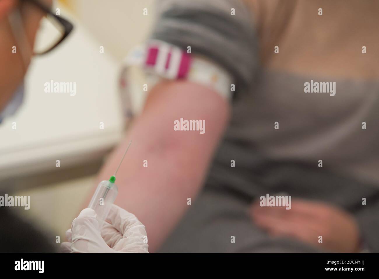 Nurse holding a medical needle and preparing for blood extraction out ...