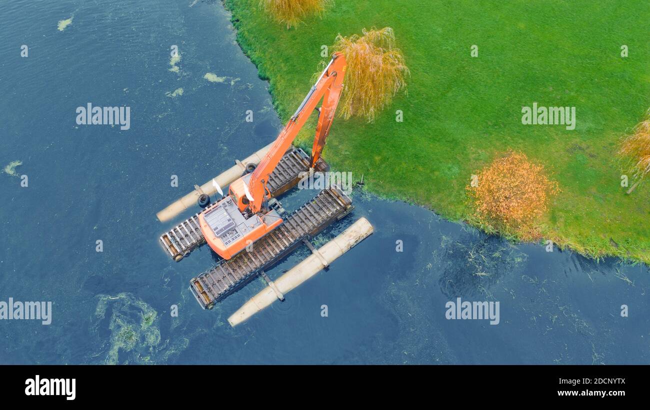Floating excavator for cleaning ponds, aerial view. Provision of water