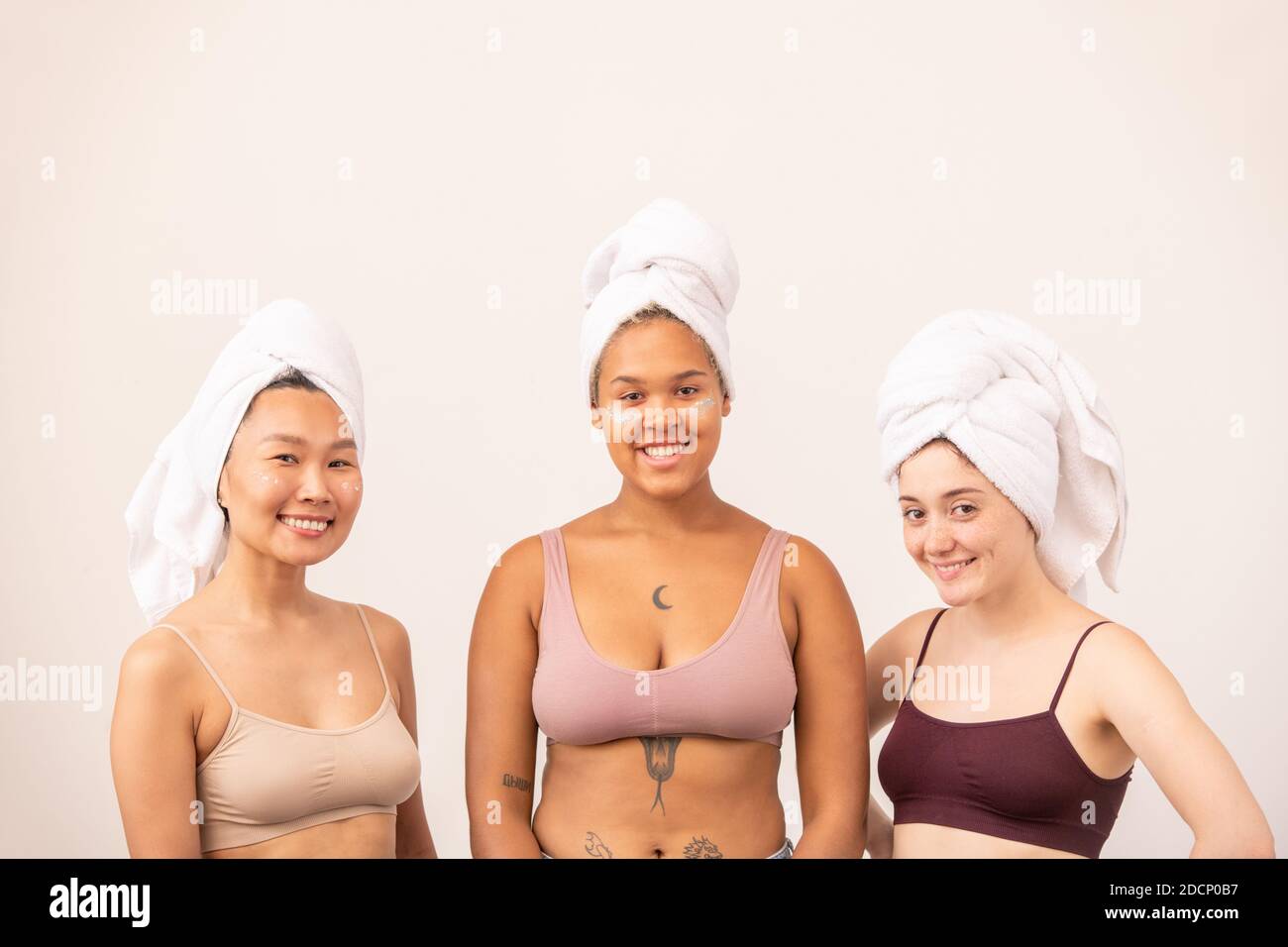 Cute Asian, African and Caucasian girls with soft towels on heads and tanktops Stock Photo