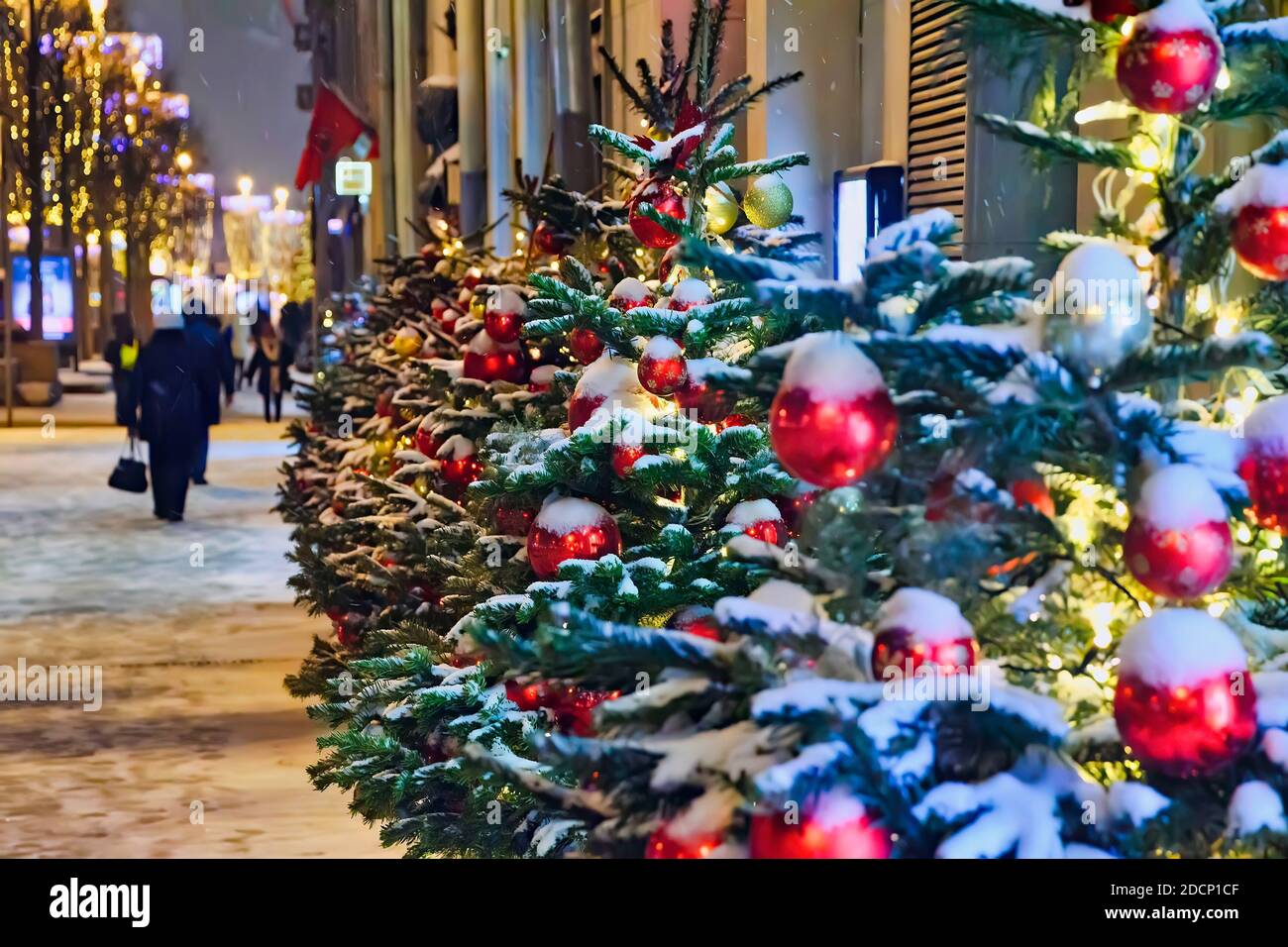 Christmas tree with red balloons on city street at night Stock Photo ...