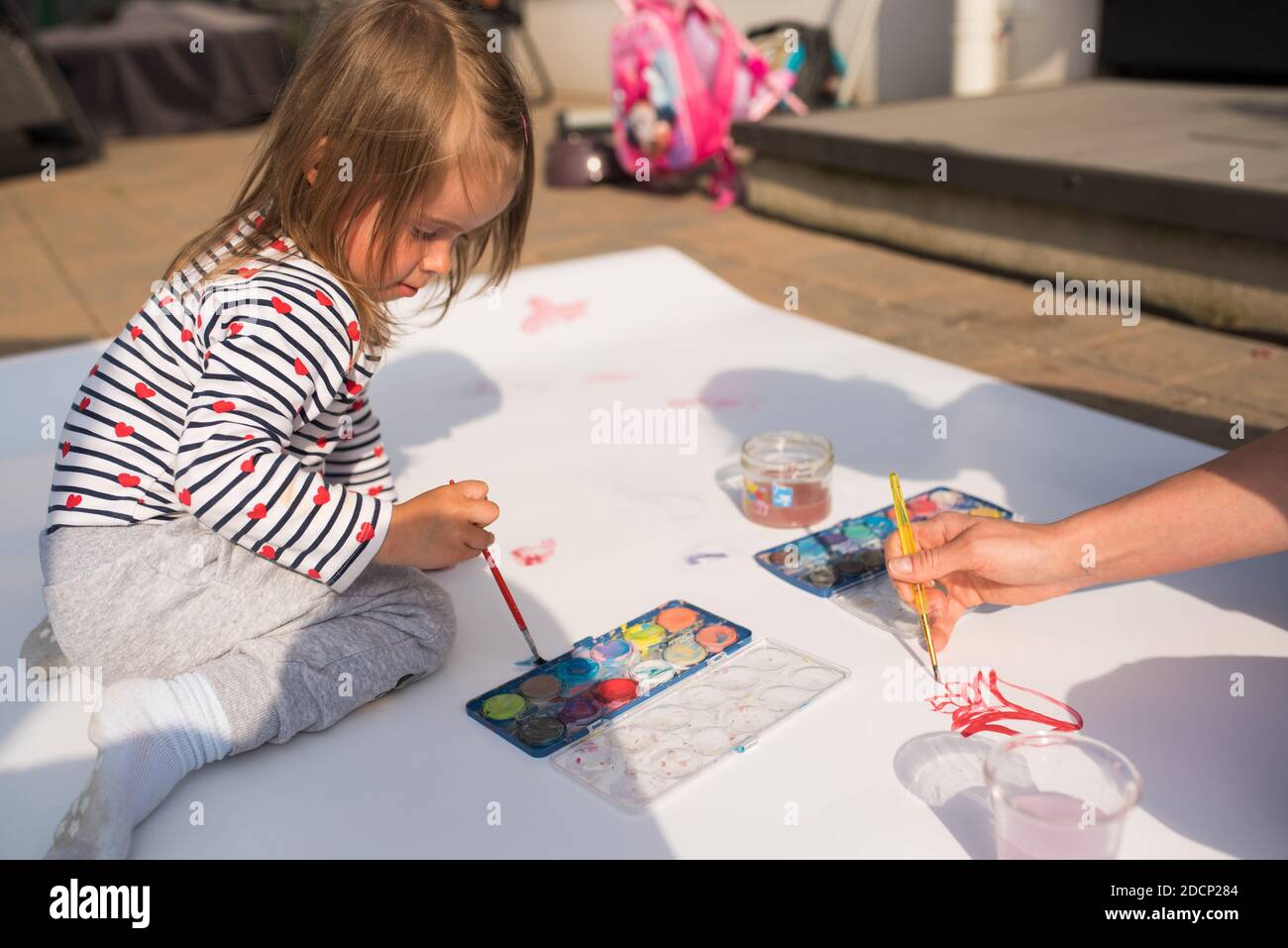 Child With Mother Painting With Poster Paint Outdoors On The Ground On Child with mother painting with poster paint outdoors on the ground on
