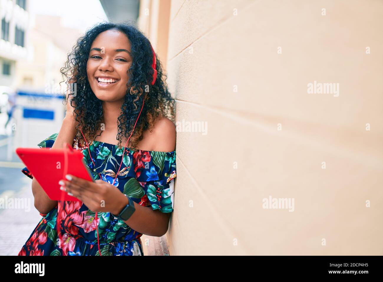 Young african american woman with curly hair smiling happy outdoors ...