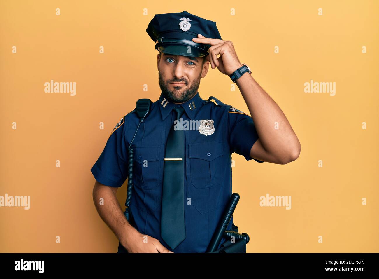 Handsome hispanic man wearing police uniform worried and stressed about a problem with hand on forehead, nervous and anxious for crisis Stock Photo