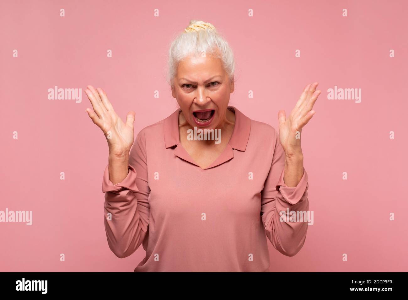 Frustrated and angry senior hispanic woman screaming. Stock Photo