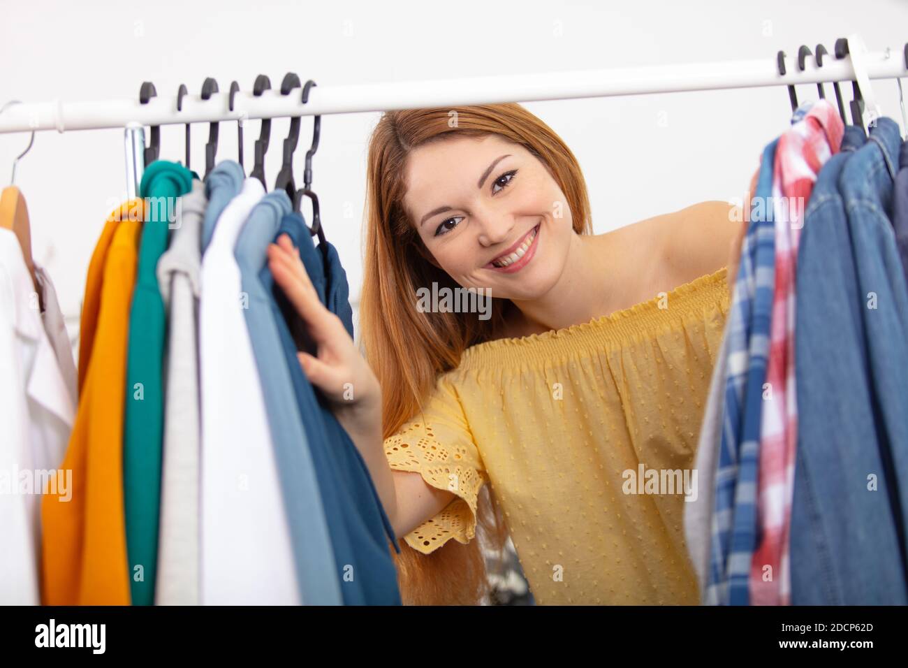 young and cheerful woman choosing casual clothes to wear Stock Photo