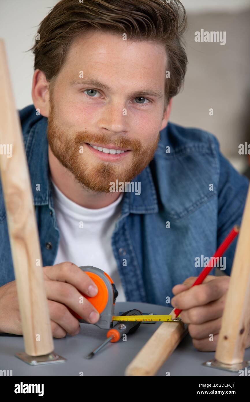 man tries himself to fold his coffee table and stools Stock Photo Alamy