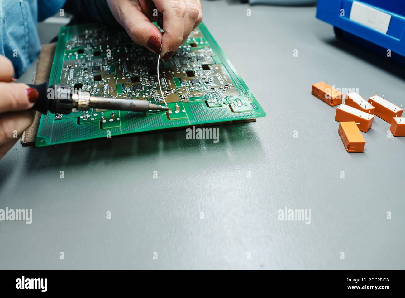 person welding with a soldering iron on a motherboard Stock Photo Alamy
