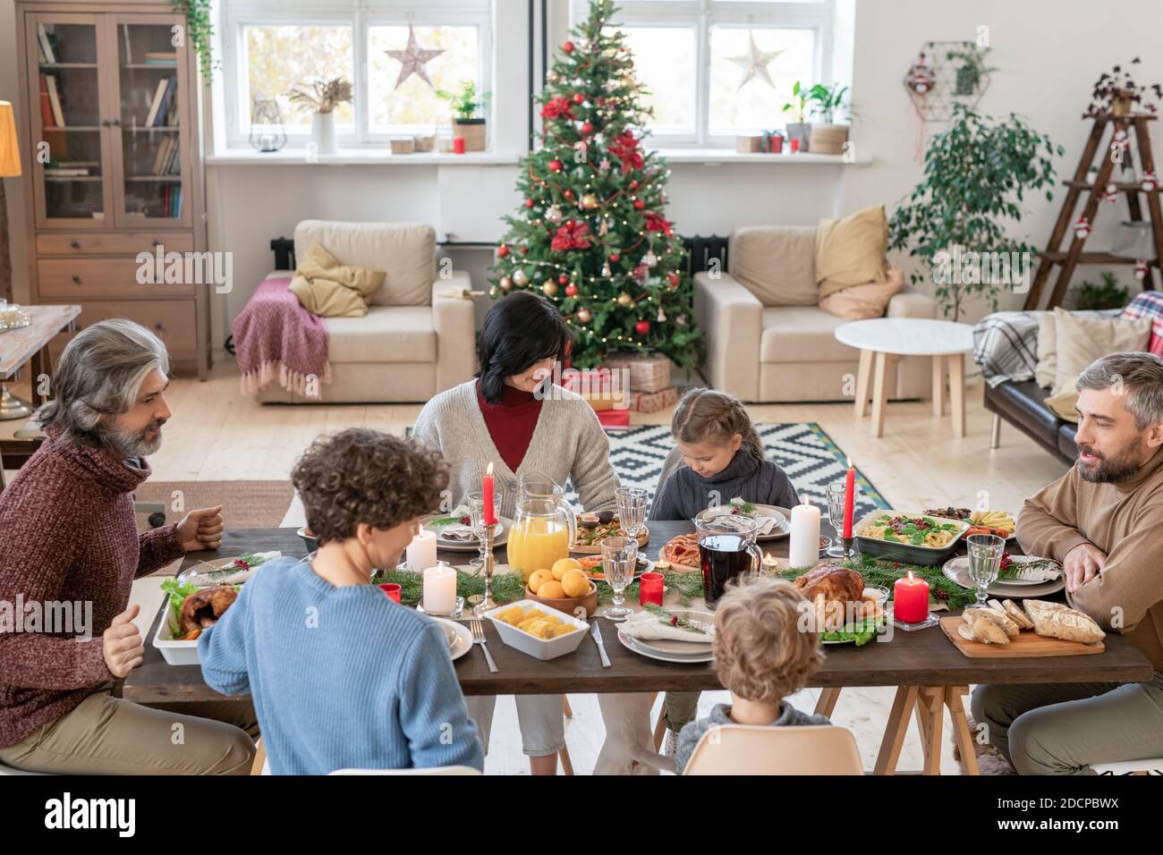 Large family consisting of three generations dining by served festive table Stock Photo