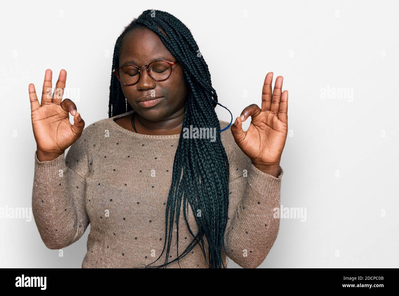 Young black woman with braids wearing casual clothes and glasses relax ...