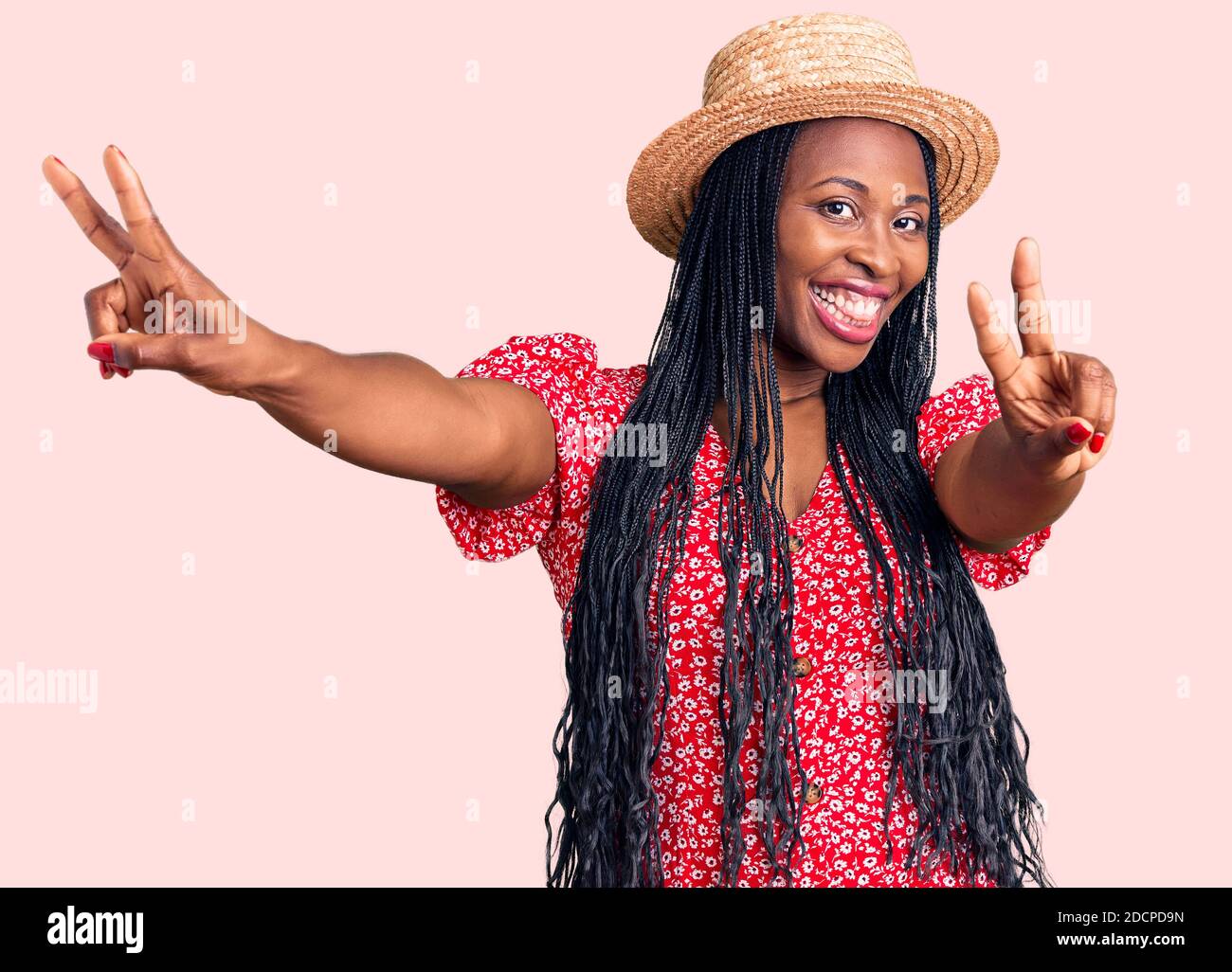 Young african american woman wearing summer hat smiling with tongue out ...