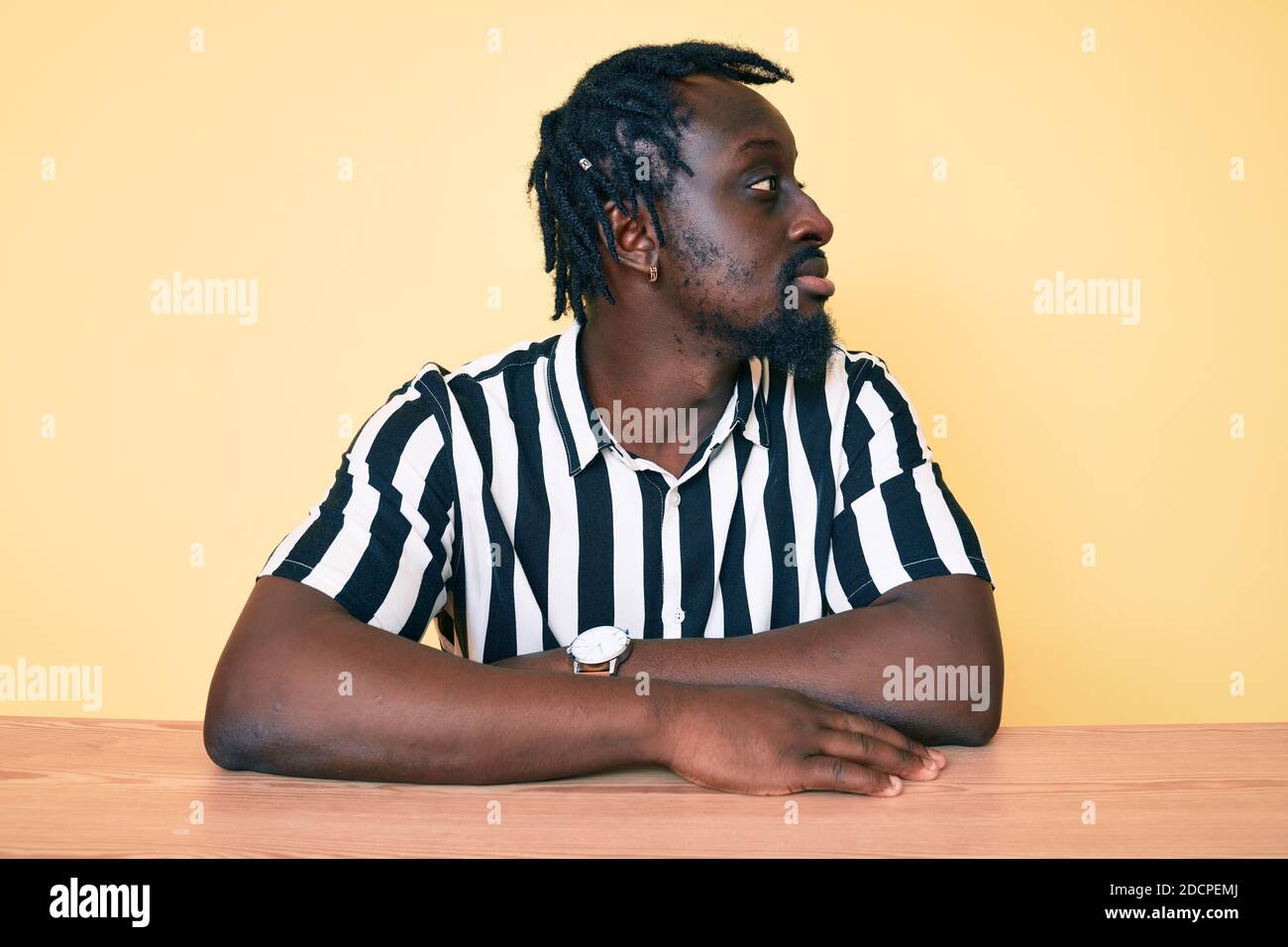 Young african american man with braids wearing casual clothes sitting ...