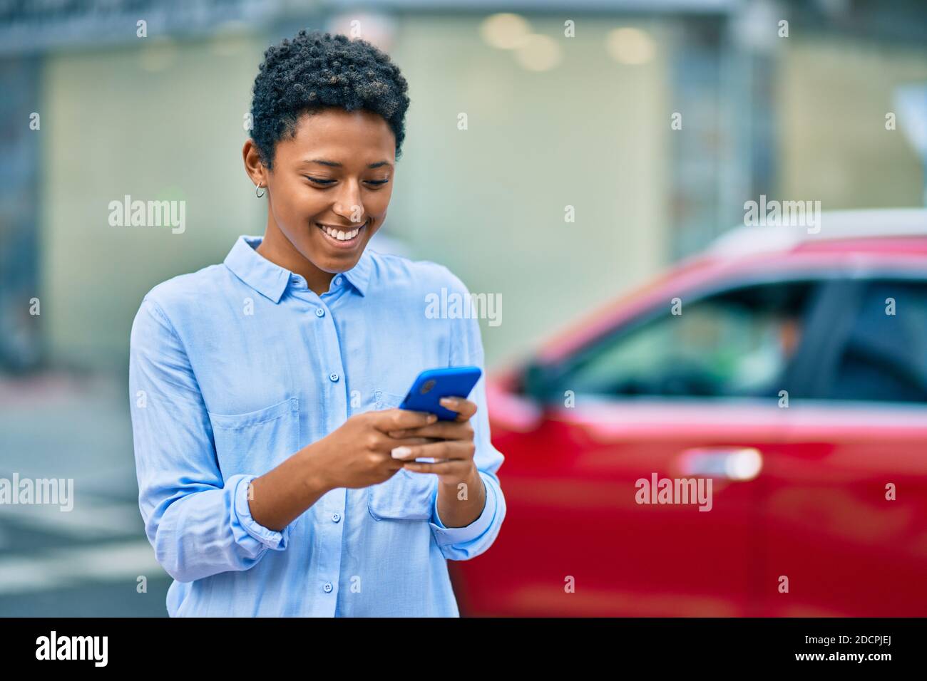 Young african american girl smiling happy using smartphone at the city ...