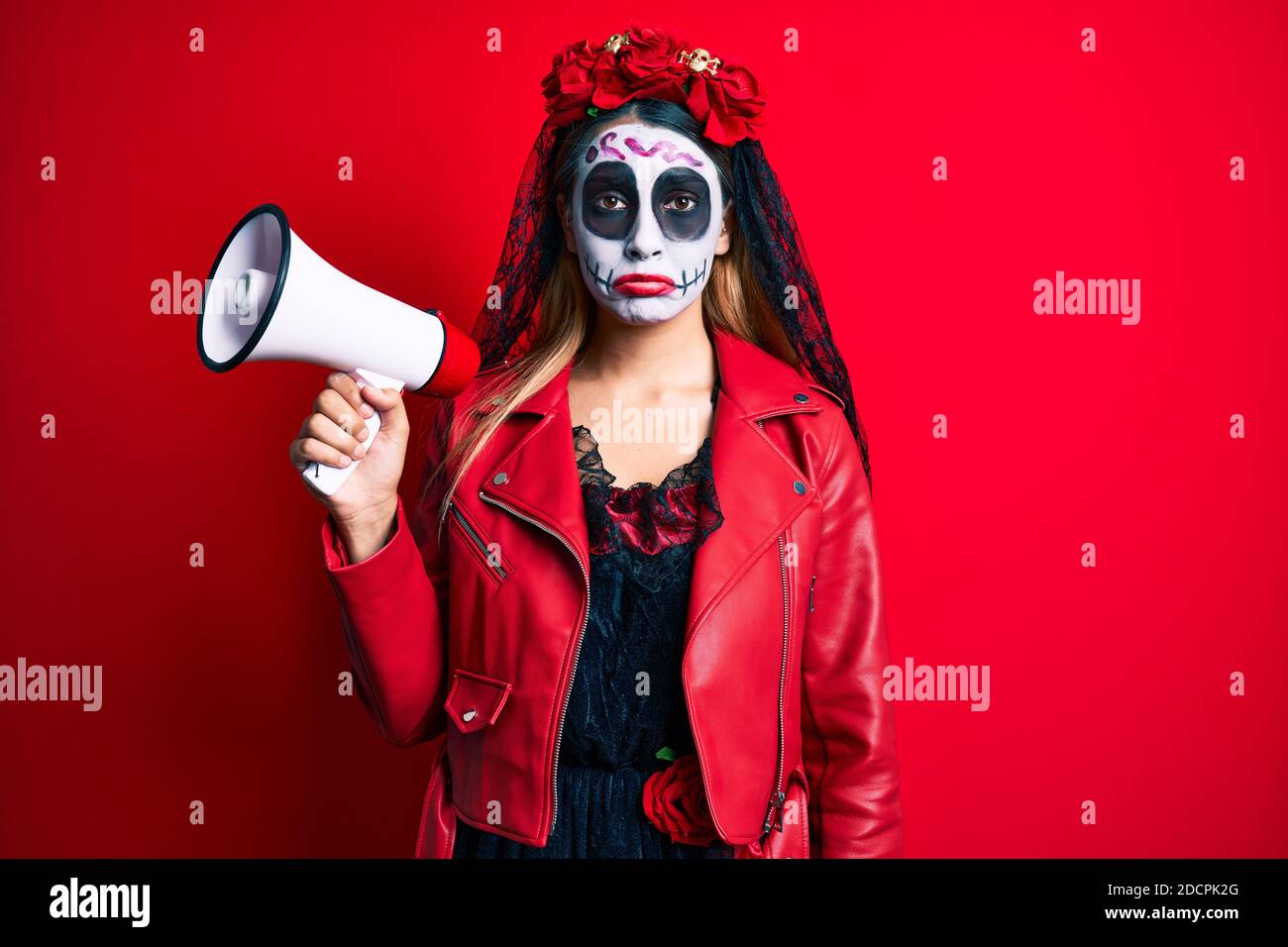 Woman wearing day of the dead costume using megaphone depressed and ...