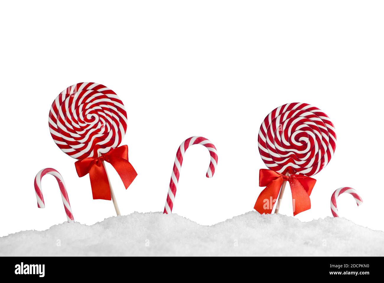 Christmas red candy canes and lollipops in snow isolated on white background. Merry Christmas sweets and Happy New Year concept Stock Photo
