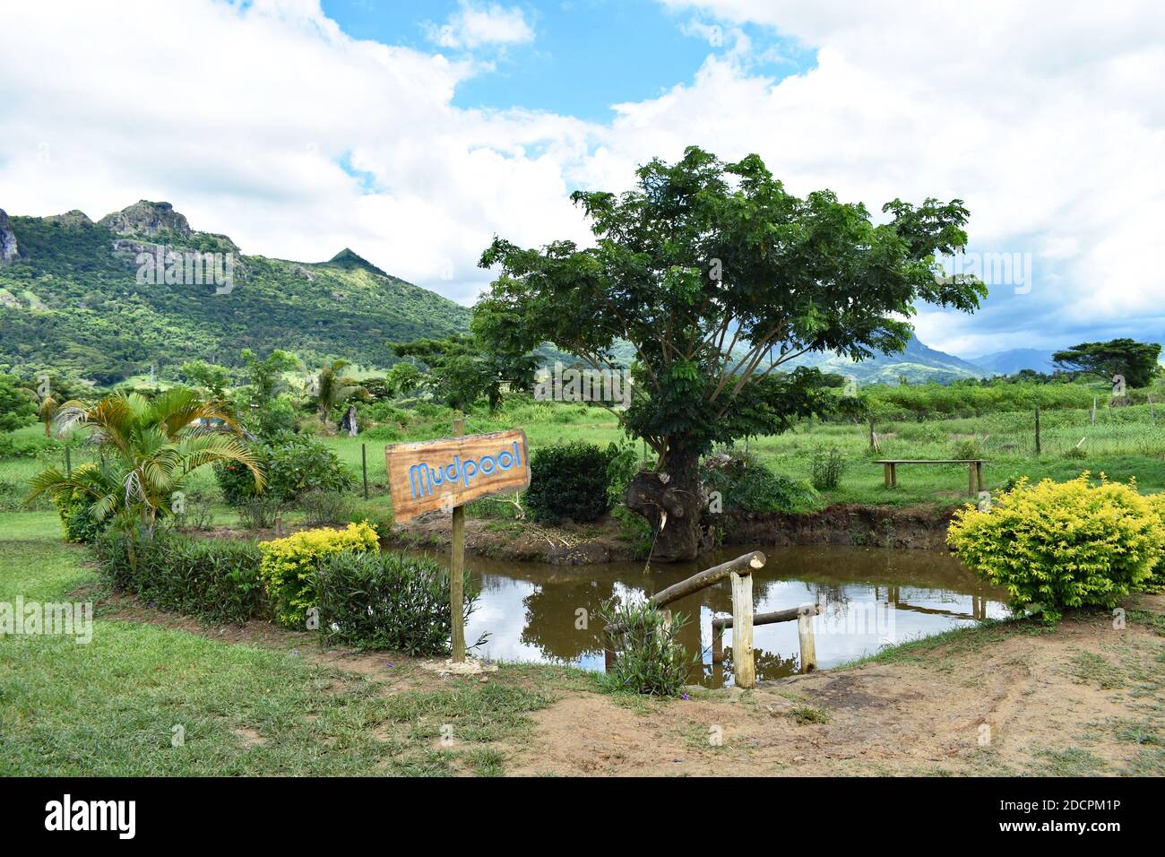 Tifajek Mud Pool & Hotspring backed by the Mountains of the Sleeping Giant in Nadi, Fiji.  A signpost reads Mudpool and railings lead into the water. Stock Photo