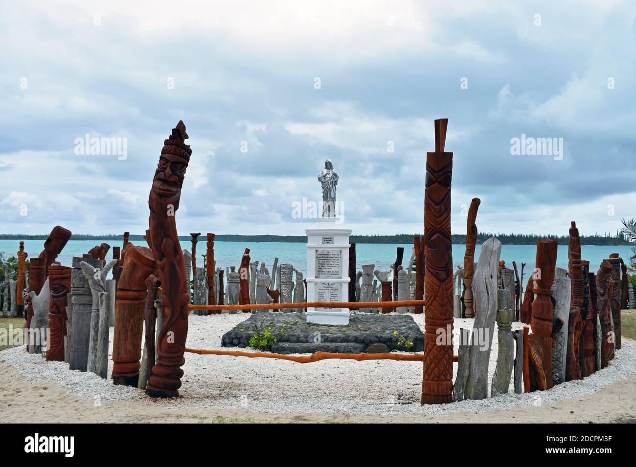 A sculpture of Saint-Maurice in Vao, Isle of Pines, New Caledonia.  The statue is surrounded by a fence made of carved wooden totems. Stock Photo