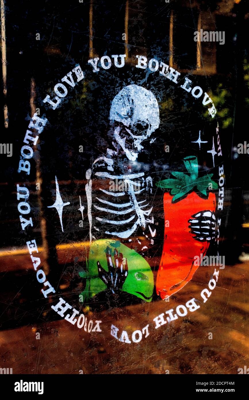 symbol of 'death' depicting love for both red and green chili peppers on store window in downtown Albuquerque, New Mexico Stock Photo