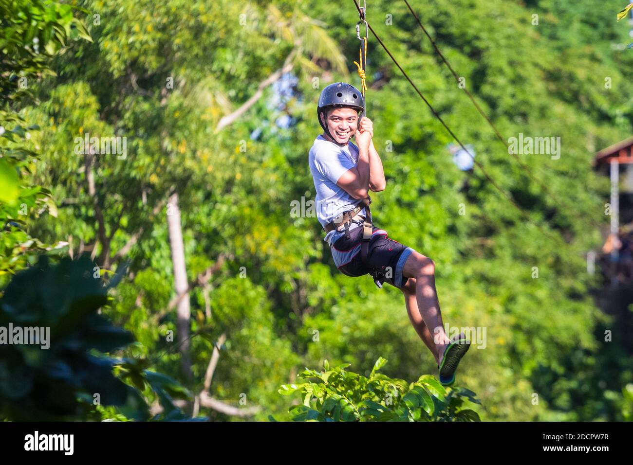 A young Filipino male enjoying a zip line in Corregidor Island, Philippines Stock Photo