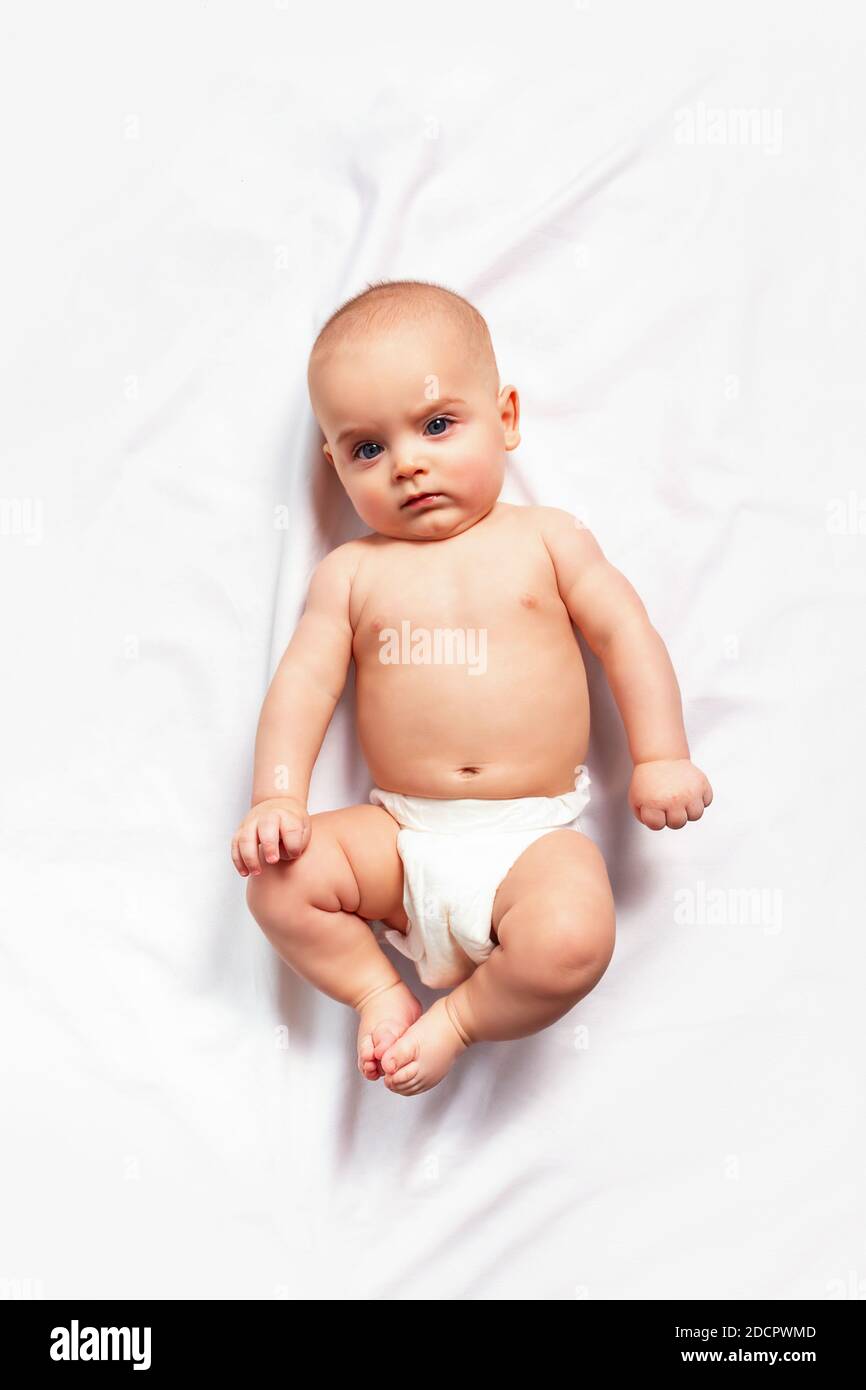 Caucasian funny child in white nappy lies on light background. Top view.  Children's hygiene, nappy change and baby skin care Stock Photo - Alamy