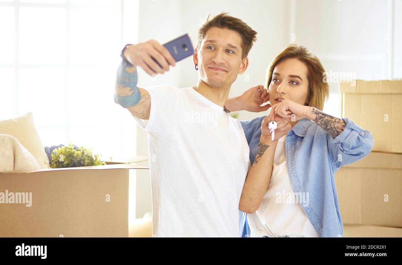 Happy smiling young couple showing a pair of keys of their new house ...