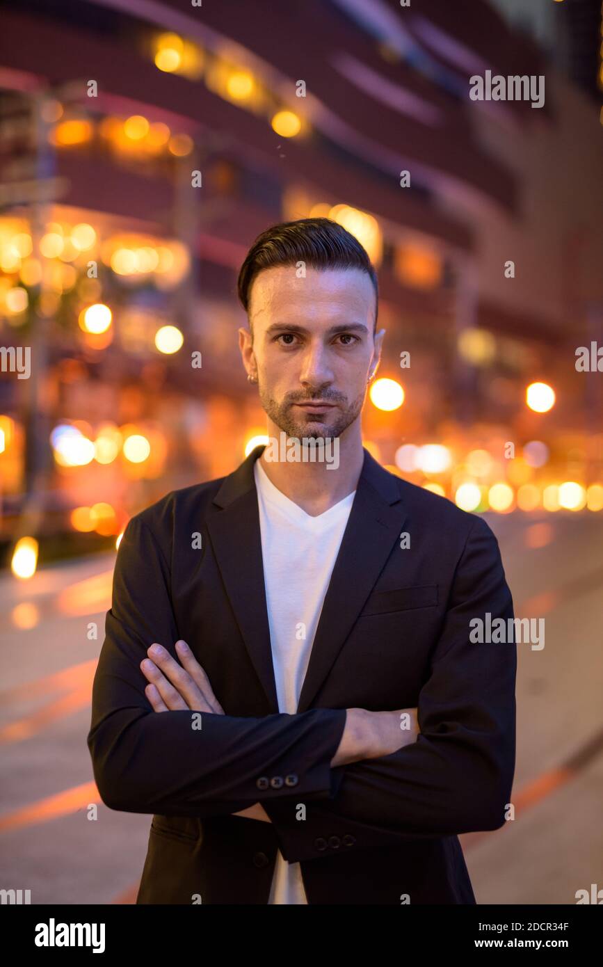Portrait of young businessman against a city by night Stock Photo - Alamy