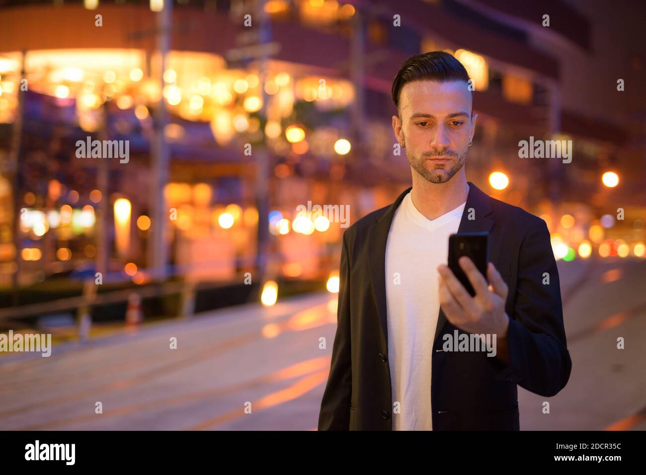 Portrait of young businessman against a city by night Stock Photo - Alamy