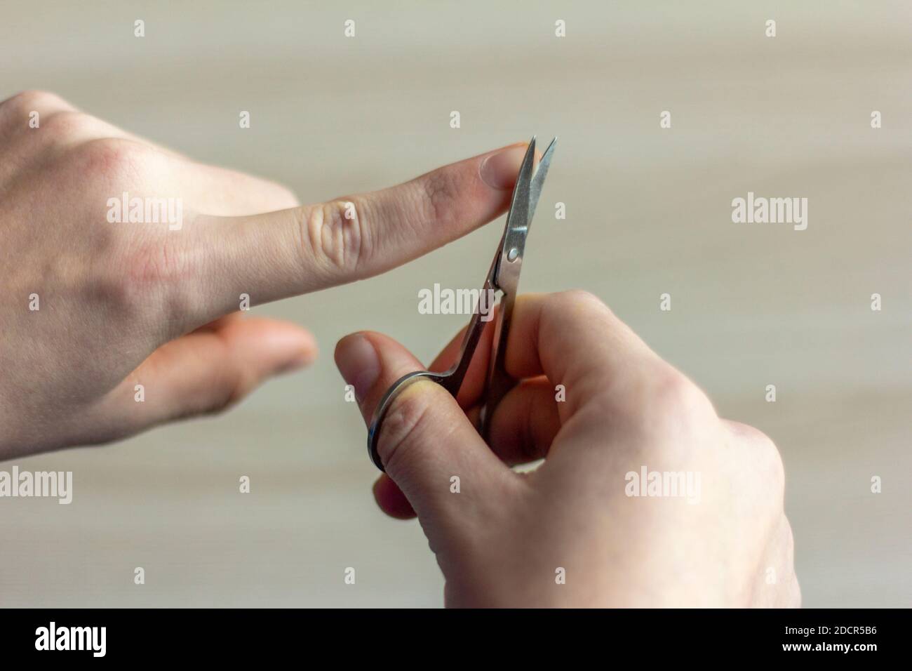 Cut your nails. A young man cuts his nails with nail scissors. Taking care  of your appearance and yourself Stock Photo - Alamy
