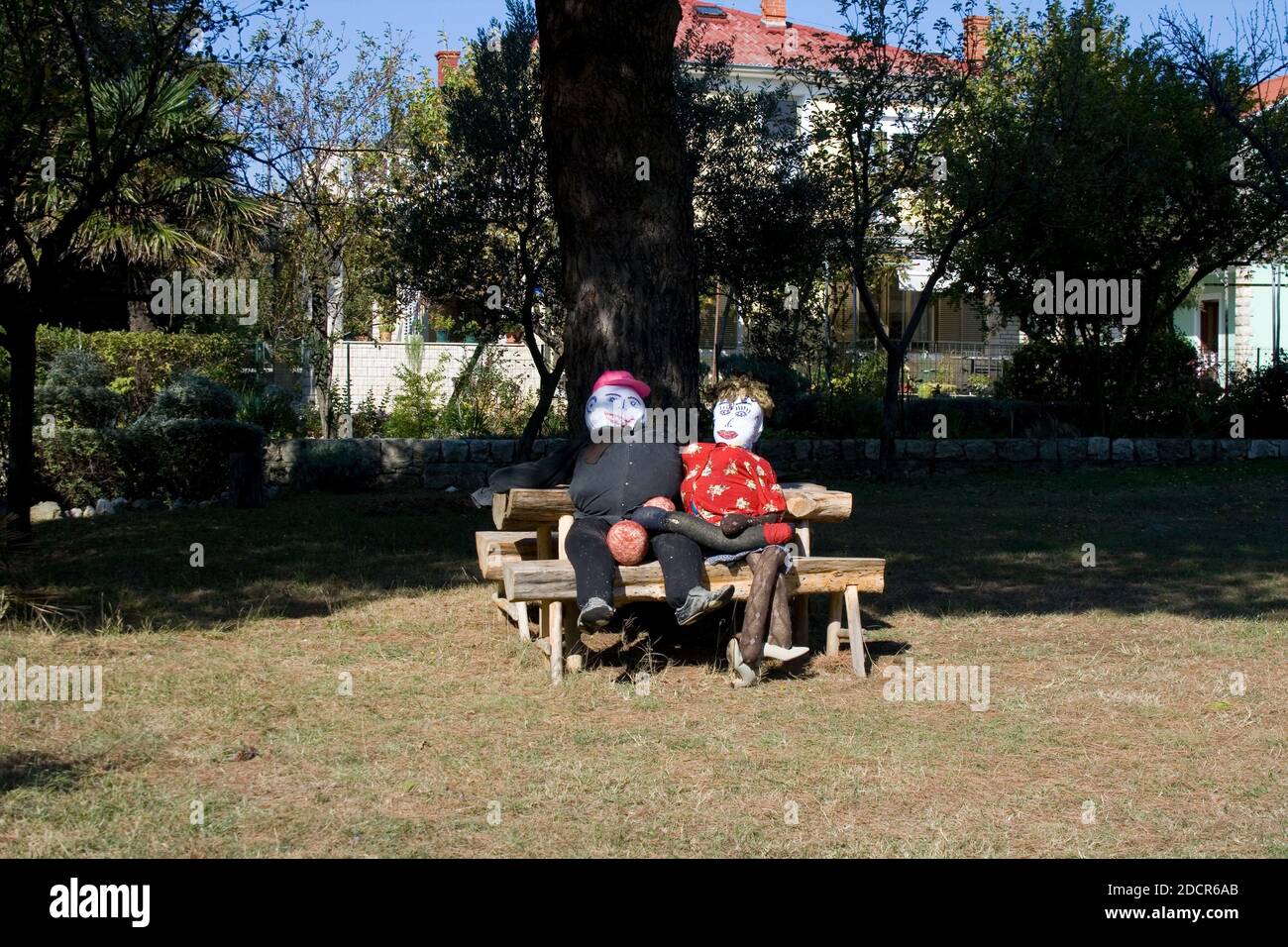 View of two funny puppets sitting in a park bench