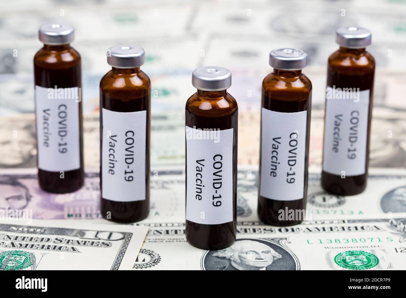 Vaccine against Covid-19 on the background of American Dollars Stock Photo