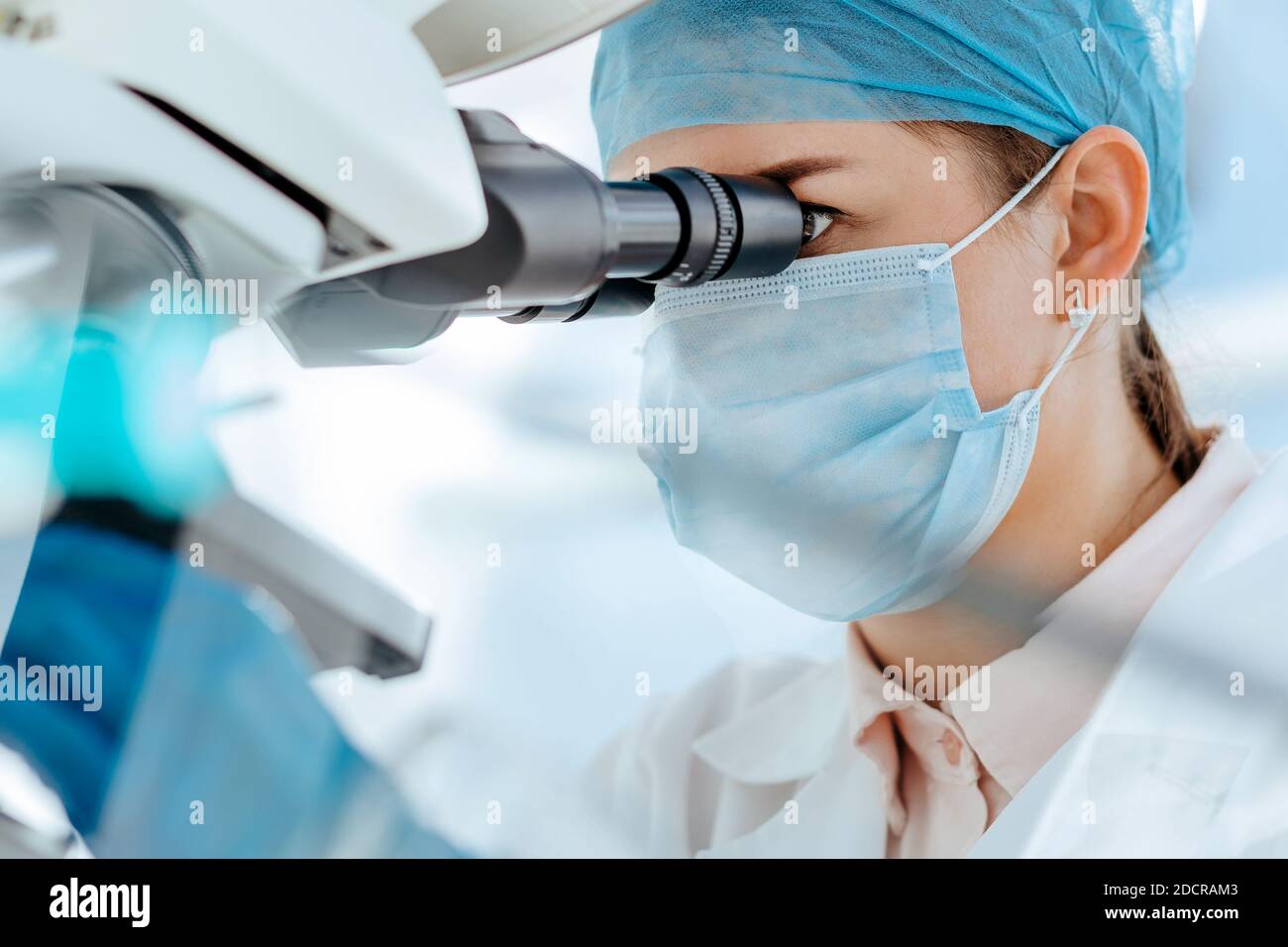 female scientist using a microscope in a medical laboratory. Stock Photo