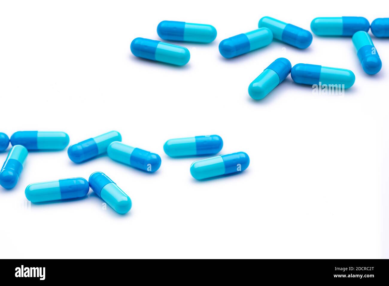 Blue capsule pills on white background. Pharmaceutical industry. Pharmacy or drugstore products. Healthcare and medicine. Health budget concept. Stock Photo