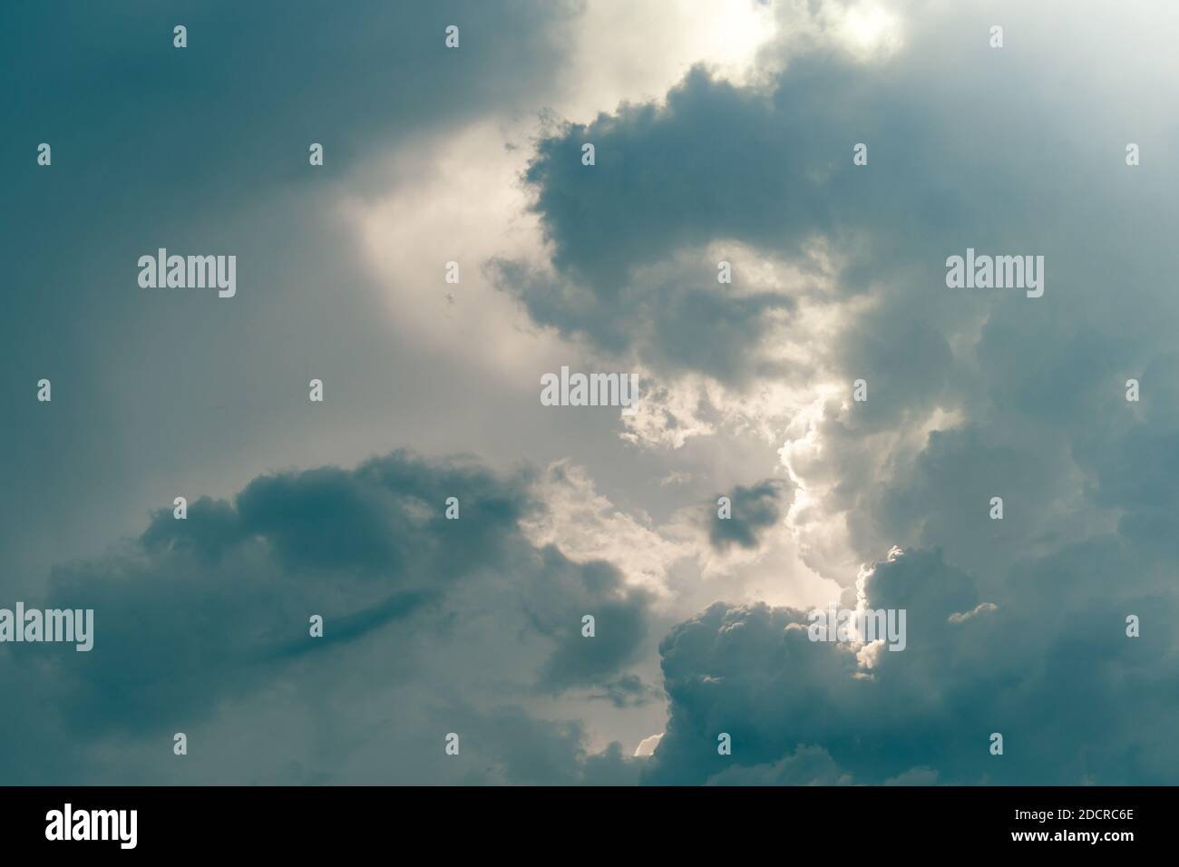 Gray sky and fluffy clouds with sunlight. Cloudy sky. Background for death and sad concept. Sad and moody sky. Nature background. Cloudscape. Hope. Stock Photo