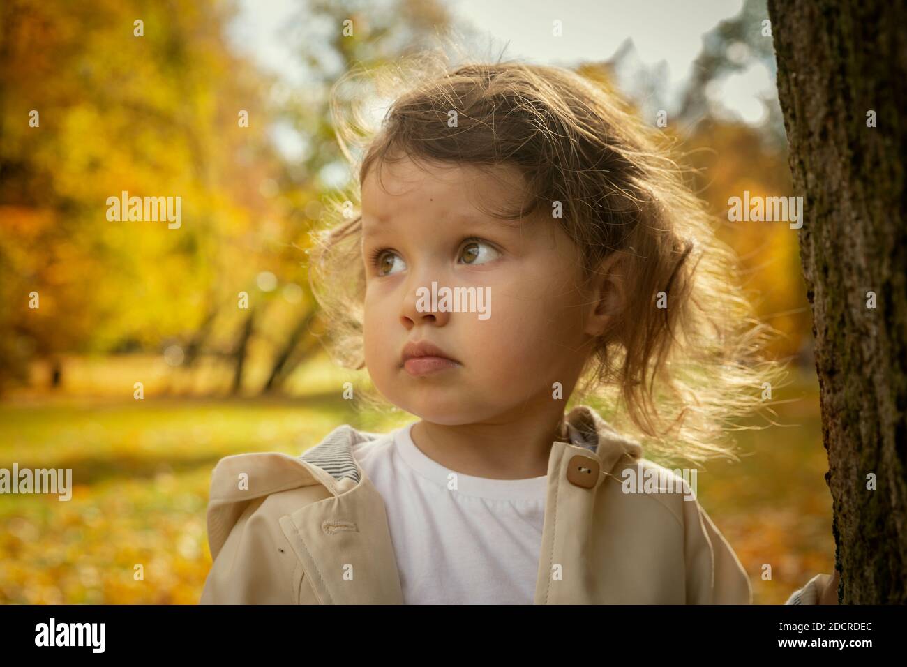 Sad baby girl in an autumn park Stock Photo