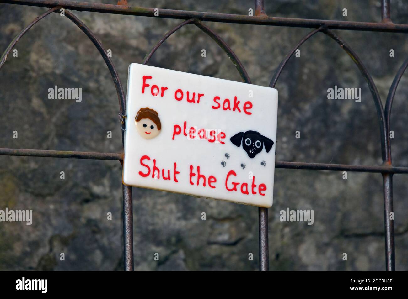 'For our sake please shut the gate'. Sign on wrought iron gate, Low Fellside, Kendal, Cumbria, England, United Kingdom, Europe. Stock Photo