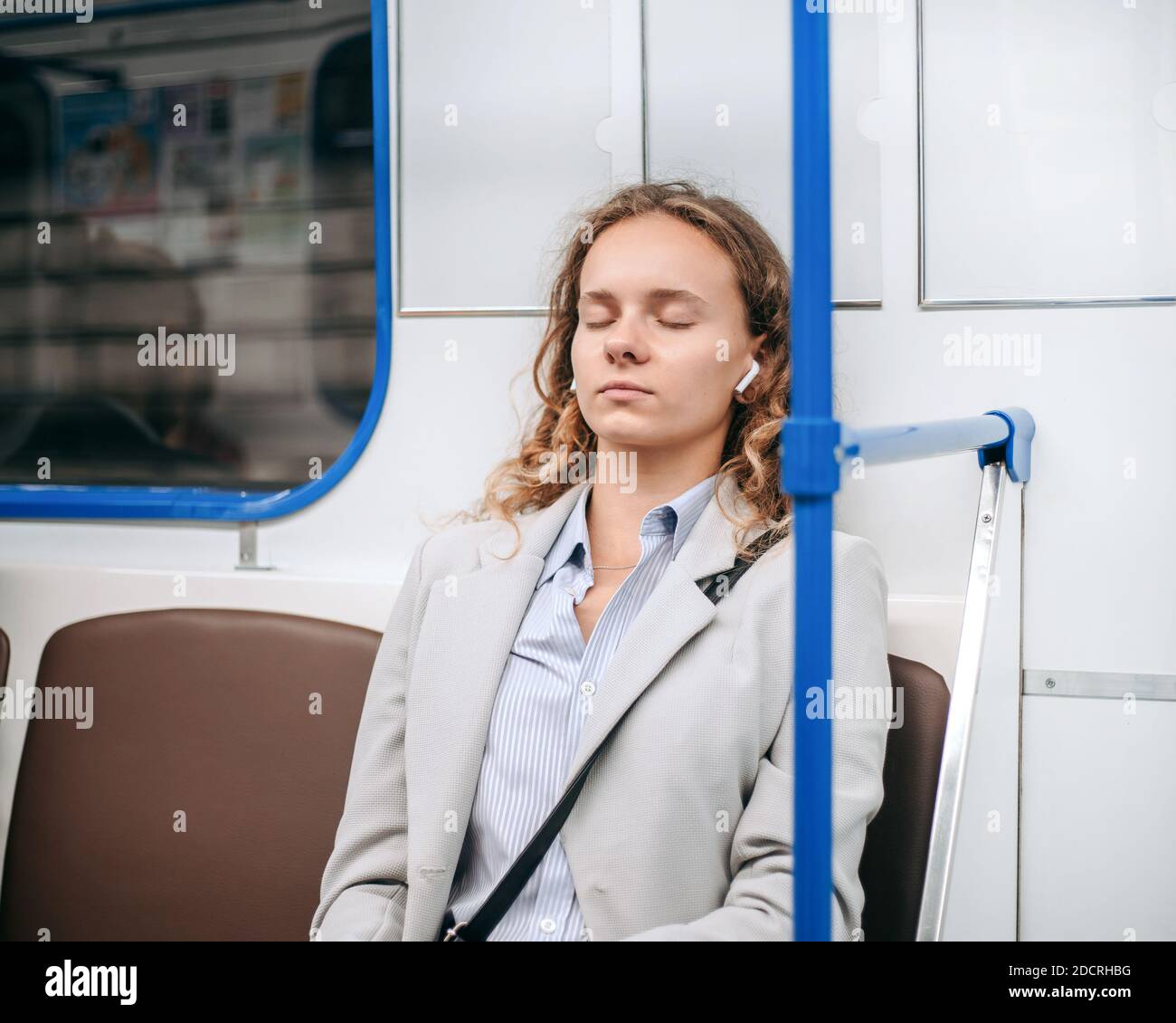 tired young woman sleeps on a subway train Stock Photo - Alamy