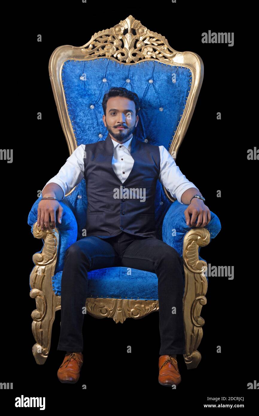 young bearded man in formal waistcoat sitting on a blue