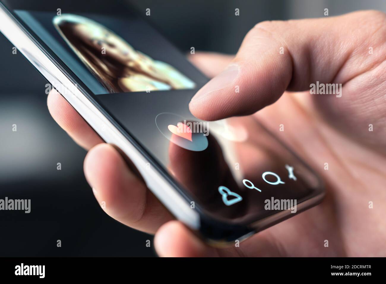 Online dating app in mobile phone. Like or swipe to match. Single man looking for love and relationship with smartphone. Woman with beautiful profile. Stock Photo