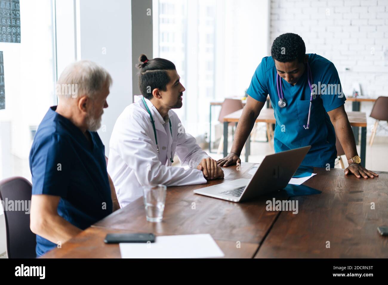 Team of multiethnic medical specialists discussing at chest Xray image during medical
