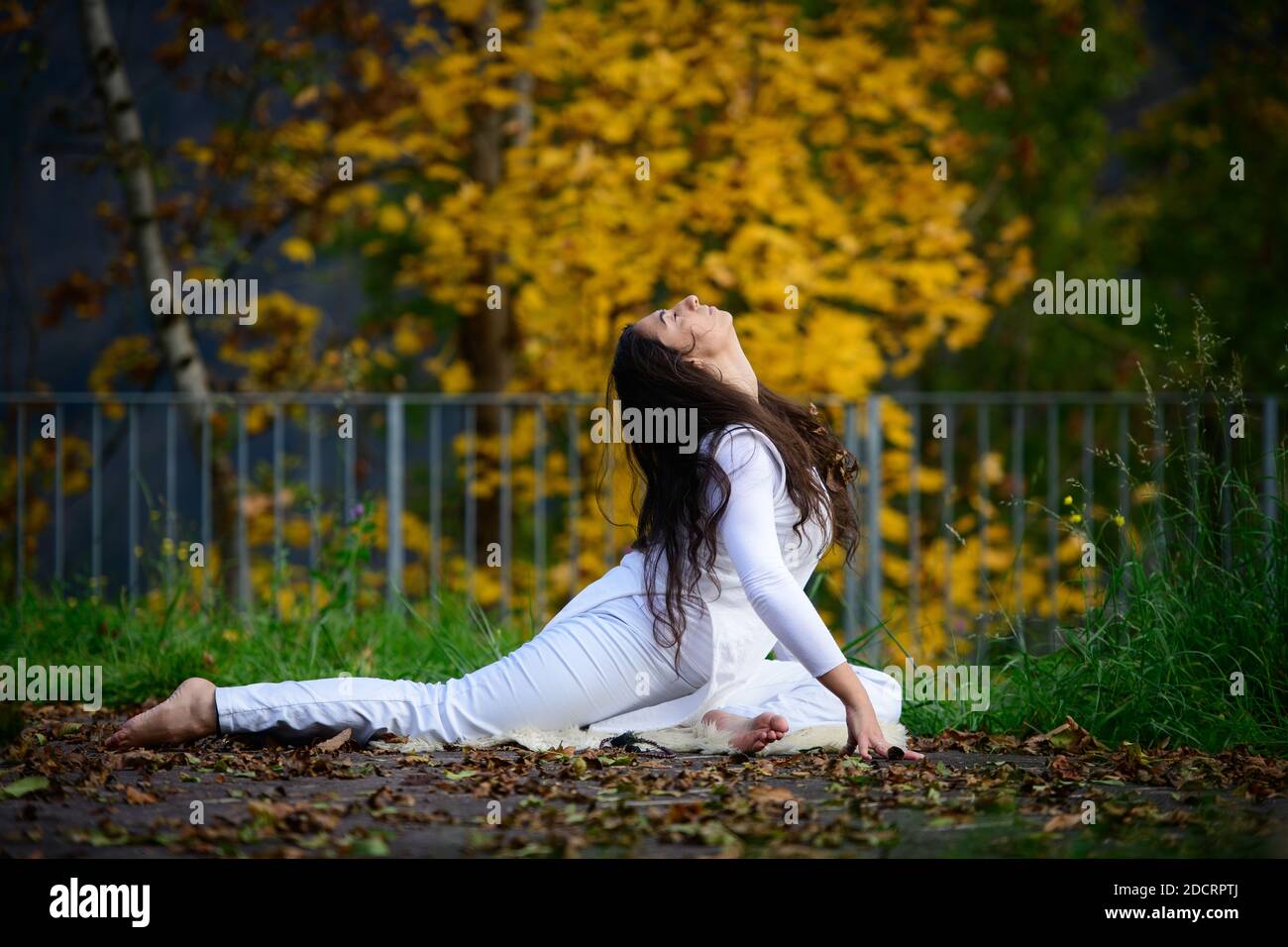 Young woman in yoga position in the park Stock Photo