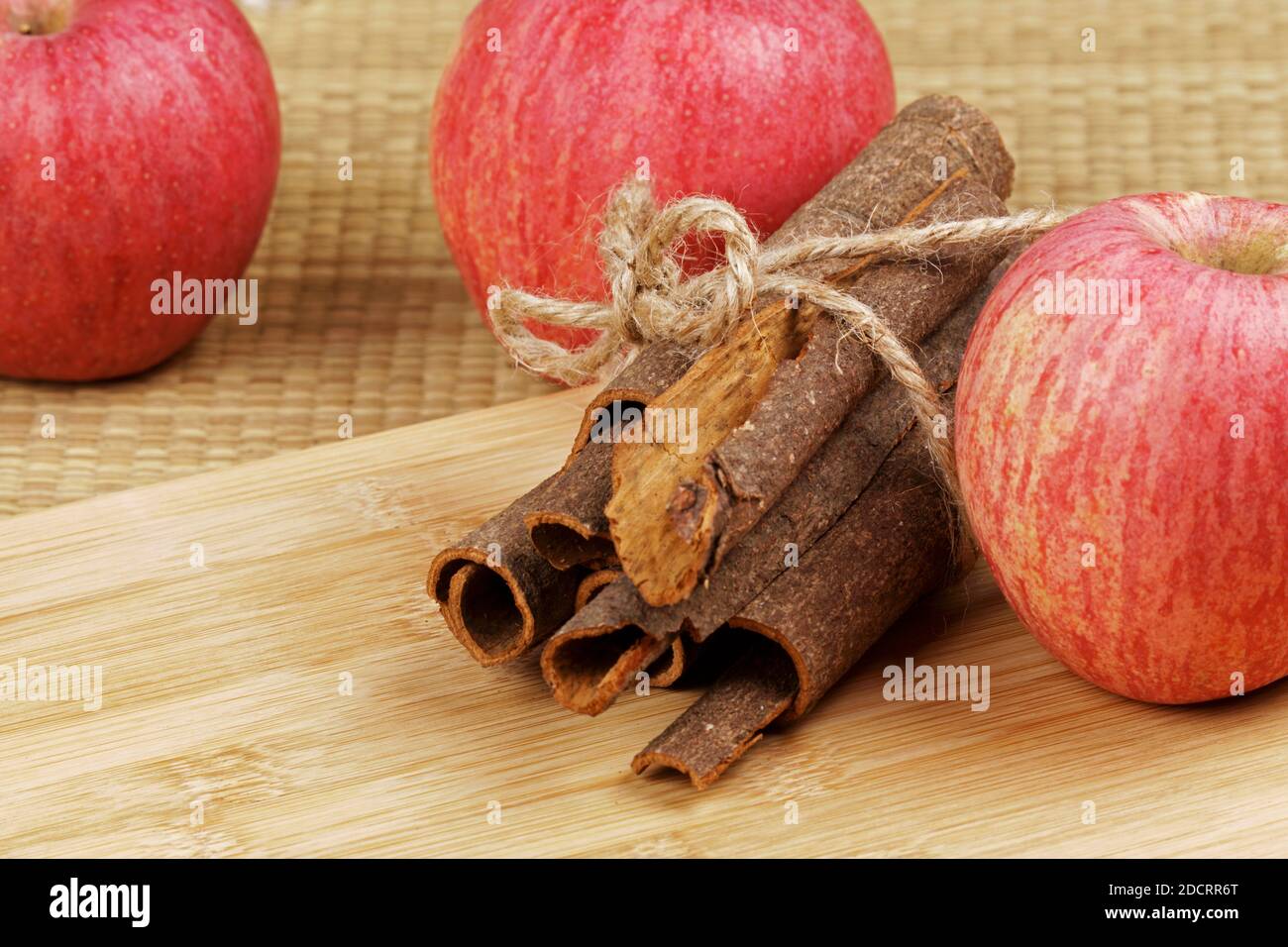 Delicious cinnamon bark and red apples on a wooden background Stock Photo