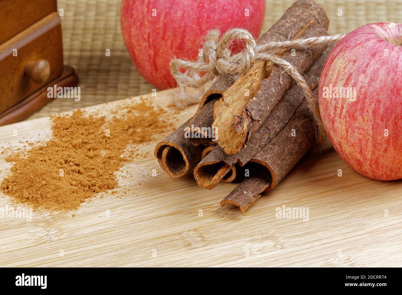 Delicious cinnamon power, cinnamon bark and red apples on a wooden background Stock Photo